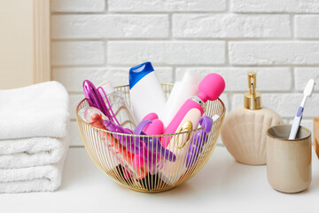 Wall Mural - Basket with bath accessories and sex toys on table in bathroom, closeup