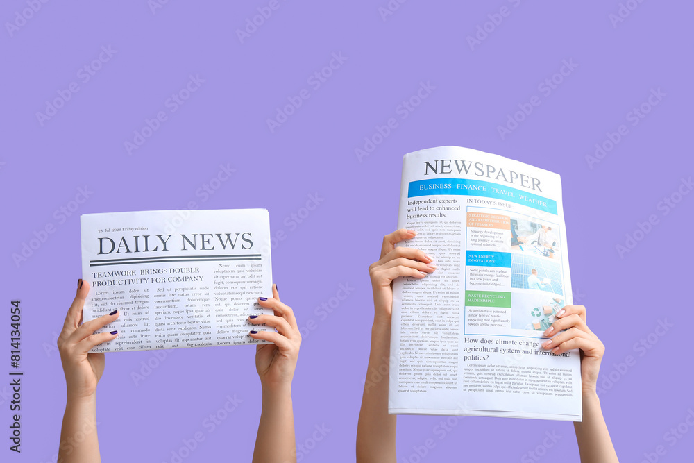 Female hands with newspapers on lilac background
