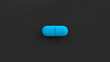 Blue single pill isolated on a black background. Tablet, pill top view, flat lay. 3d render illustration 