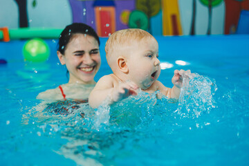 Wall Mural - Swimming pool for babies. A baby learns to swim with a coach