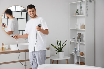 Poster - Young man with trimmer in bathroom