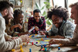 © AndyGordon - Friends gathered around a table playing board games, laughing as they compete and enjoy each other's company