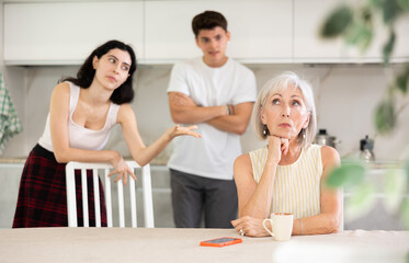 Sticker - Portrait of thoughtful elderly woman who had conflict with adult children while cooking dinner in the kitchen