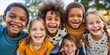 © Joaquin Corbalan - Diverse group of young children standing next to each other with cheerful expressions.