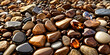 A close-up view of various types of rocks and stones, with a focus on amber-colored stones that have a smooth, polished surface.