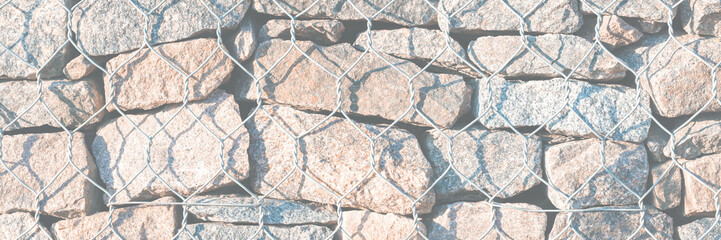 Wall Mural - Wall of stones held by a metal mesh. Texture for background and design.