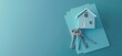 © DWN Media - 3D illustration of silver keys with house model on blue paper, real estate concept, top view banner background.