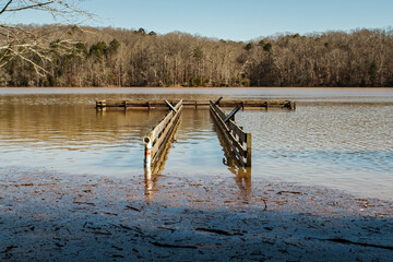 Wall Mural - a flooded lake with pier underwater and debris floating on surface