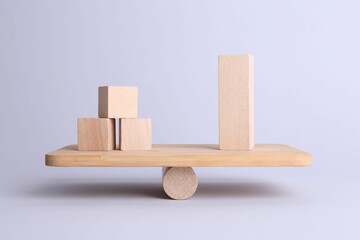 Wall Mural - Equality concept. Seesaw scale with wooden blocks on light background