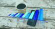 Image of arrow on growing graph over coffee cup and cellphone on wooden table