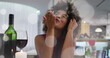 Image of spots over african american woman drinking wine and having image call