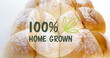 Image of 100 percent home grown text banner against close up of fresh bread on white background