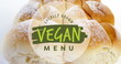 Image of locally grown vegan menu text banner against close up of fresh bread