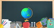 Digital image of spinning globe icon over multiple school concept icons on black board