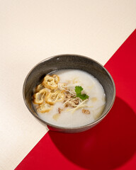 Wall Mural - Hong Kong cuisine. Porridge with dumplings, chicken and spring onions.