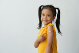 Fototapeta  - Little girl shows her arm after getting the vaccine, with a bandage on to protect against germs, first aid, treatment, medical concept, medicine and sanitation.