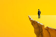 A man in a suit stands on the edge of a yellow cliff, representing decision-making and risk in a minimalistic style