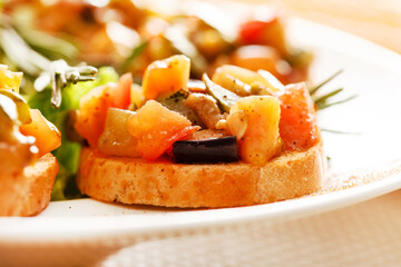 Canvas Print - bruschetta with vegetables on white plate