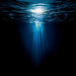 an image of the deep blue ocean taken from onderwater. there is a small beam of light coming from the surface, whenever else is very dark
