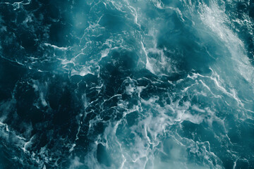 Dynamic photo of the sea's turbulent textures in shades of teal and dark blue, showcasing the chaotic energy of ocean waves