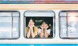 Two Happy smiling woman looks out from window traveling by train