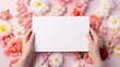 © admin_design - Blank notepaper in female hands on a background of flowers. Place for text.