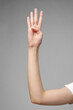 Female hand gesturing sign against gray background