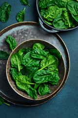 Wall Mural - Top view of ceramic plate with fresh green spinach. Creative advertising photo. Healthy food concept. Space for text.