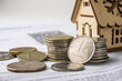 House model and coins on the background of financial documents. Real estate concept.