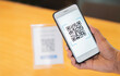 Men's hand uses a mobile phone application to scan QR codes in stores that accept digital payments without money