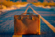 Vintage suitcase on empty road. New adventure and travel .