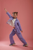 Fototapeta Na ścianę - Dancing, having fun. Cute little girl is against pink background