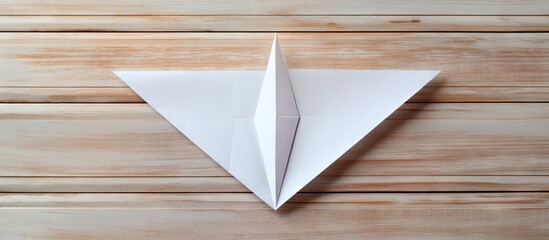 Top view of a handmade paper plane placed on a white wooden table with ample copy space image available for adding text