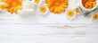A copy space image featuring calendula medical cream and bath salt placed on a white wood background with a gray canvas adorned with flowers