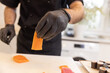 Chef, wearing gloves, preparing nigiri sushi