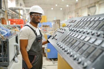 Portrait of African American male engineer in uniform and standing in industrial factory