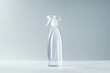 Transparent plastic spray bottle with a white background. The bottle is half-full of a clear liquid.