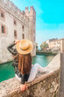 Italy, Sirmione medieval village - Tourist woman enjoying of the Scaligero Castle on the Garda lake in Brescia provence ,Lombardy. Travel Italia. Wanderlust concept.