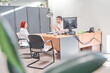© Oscar - businessman in a meeting in his office with a woman. man at the reception desk attending to his female client.