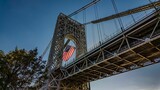 Angle shot of the George Washington Bridge in the USA, featuring a waving American flag
