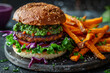 Burger with vegan patty next to sweet potato fries. Concept of plant-based meat analogs.