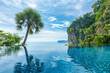 Luxury infinity pool with rainforest view below sunny blue sky