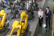 © Nassorn - Robotic engineer manager walking his female customer through plant tour in heavy machine production industry, top view. Woman business owner visit robot modern technology warehouse for inspection.