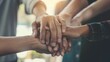 © May Chanikran - A group of diverse people joining their hands together over a blurred background.