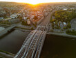 Panorama of Krakow with a railway bridge in the foreground and Wawel Castle in the background at sunset, captured by a drone.