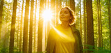 Fototapeta  - A woman enjoys the sun while walking in the forest