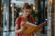 © Kinza - young smiling female reading papers, Female tourist arriving in hotel completing documents
