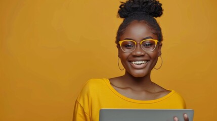 A smiling woman shopping online with a laptop on yellow background