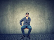 © pathdoc - handsome young man sitting on a chair thinking looking up