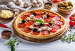 Delicious pizza pepperoni sausages with mozzarella, tomatoes and mushrooms, olives, chicken, and cheese